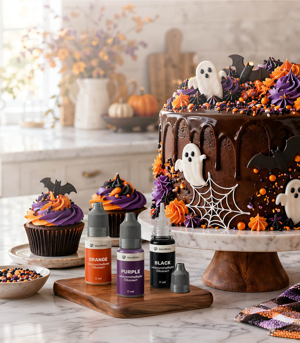 Halloween-Torte mit Schokoladen-Drip, Geistern und Fledermäusen, Cupcakes in Orange und Lila, davor ölbasierte Lebensmittelfarben in Orange, Lila und Schwarz