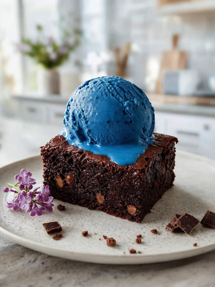 Schoko-Brownie mit einer Kugel blauem Eis, gefärbt mit ölbasierter Lebensmittelfarbe